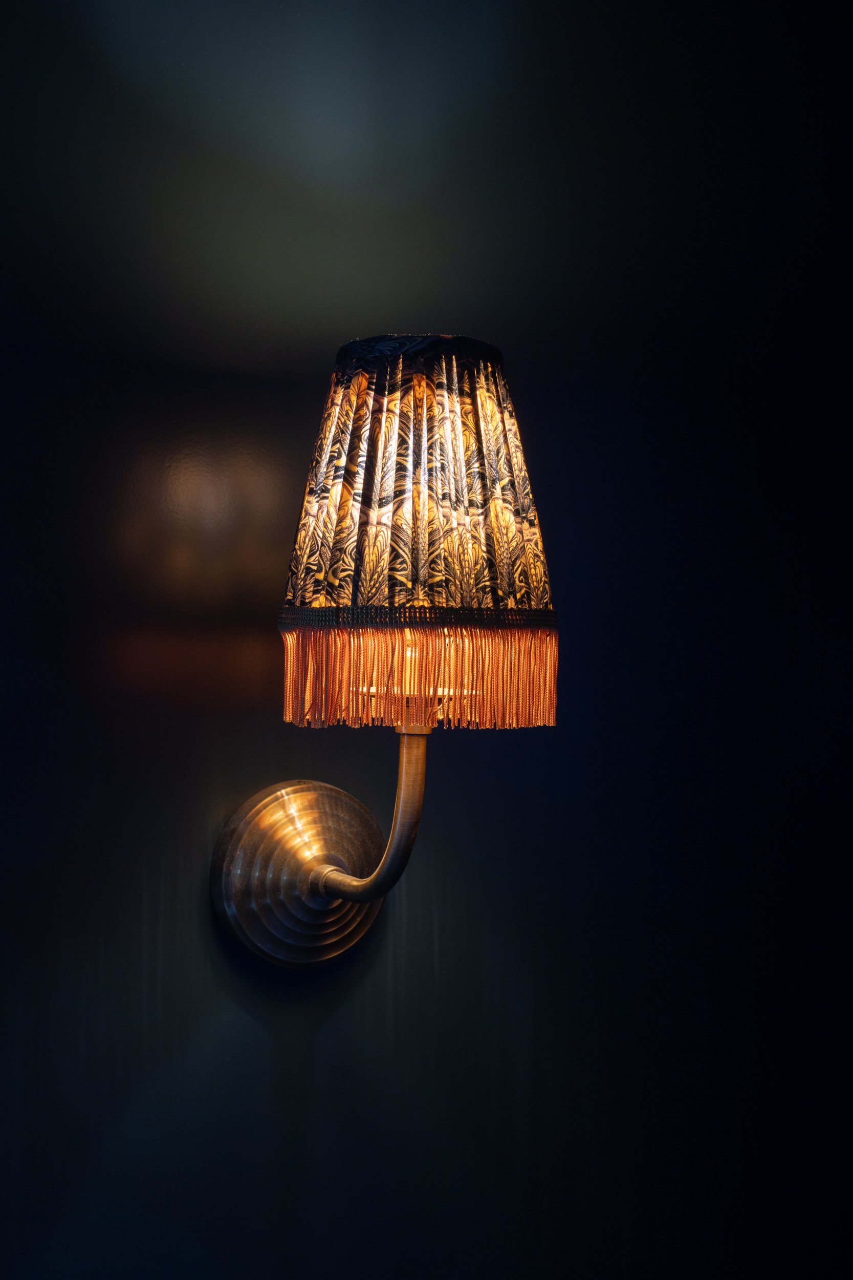 Wall sconce with decorative lampshade for stylish interior lighting.