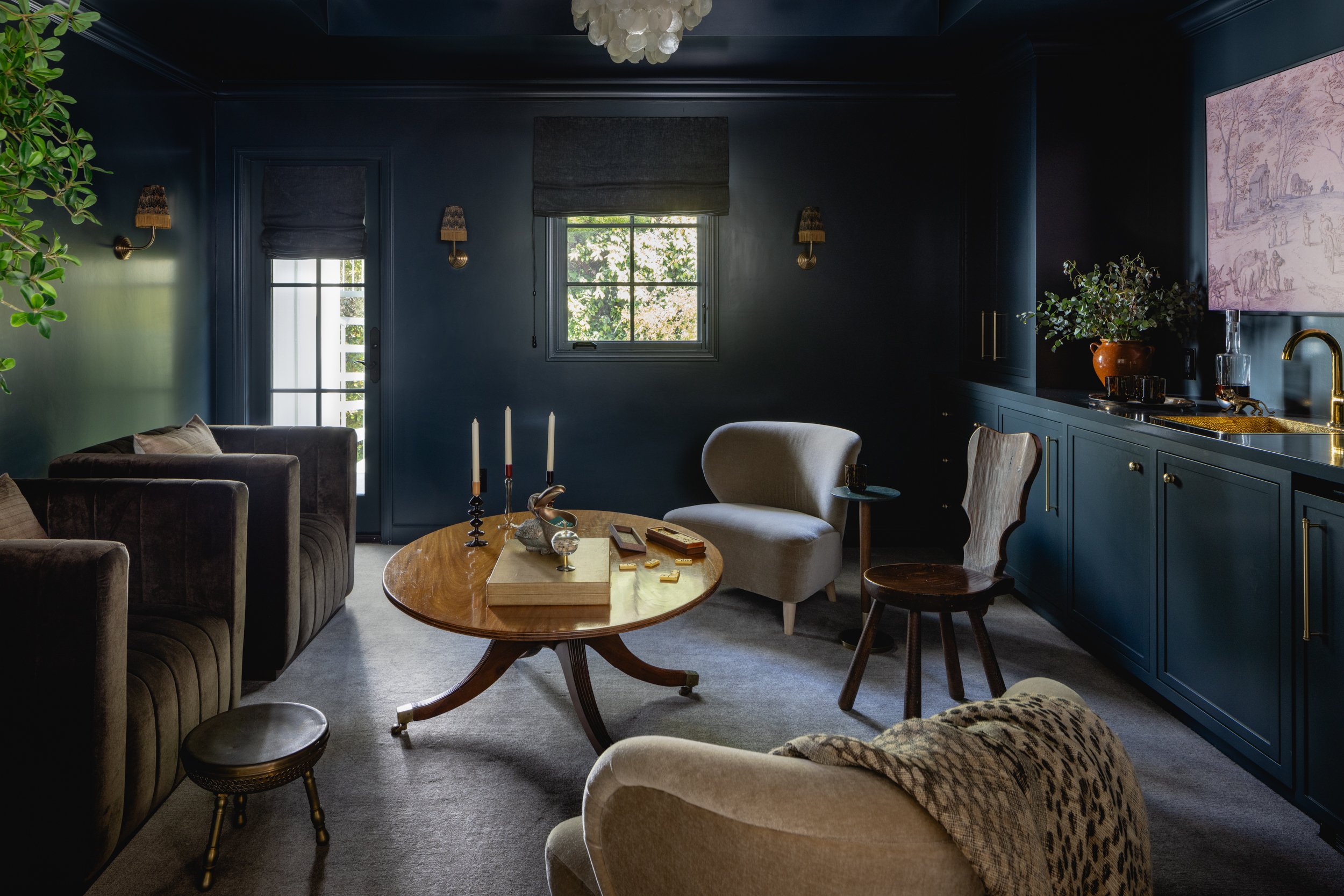 Stylish living room featuring navy blue walls and cozy seating arrangements.