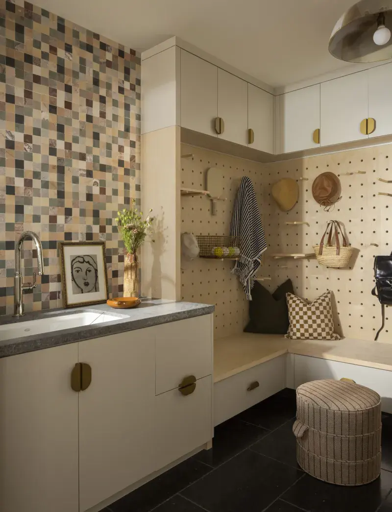 Laundry room interior featuring organized cabinets and a cozy seating nook.