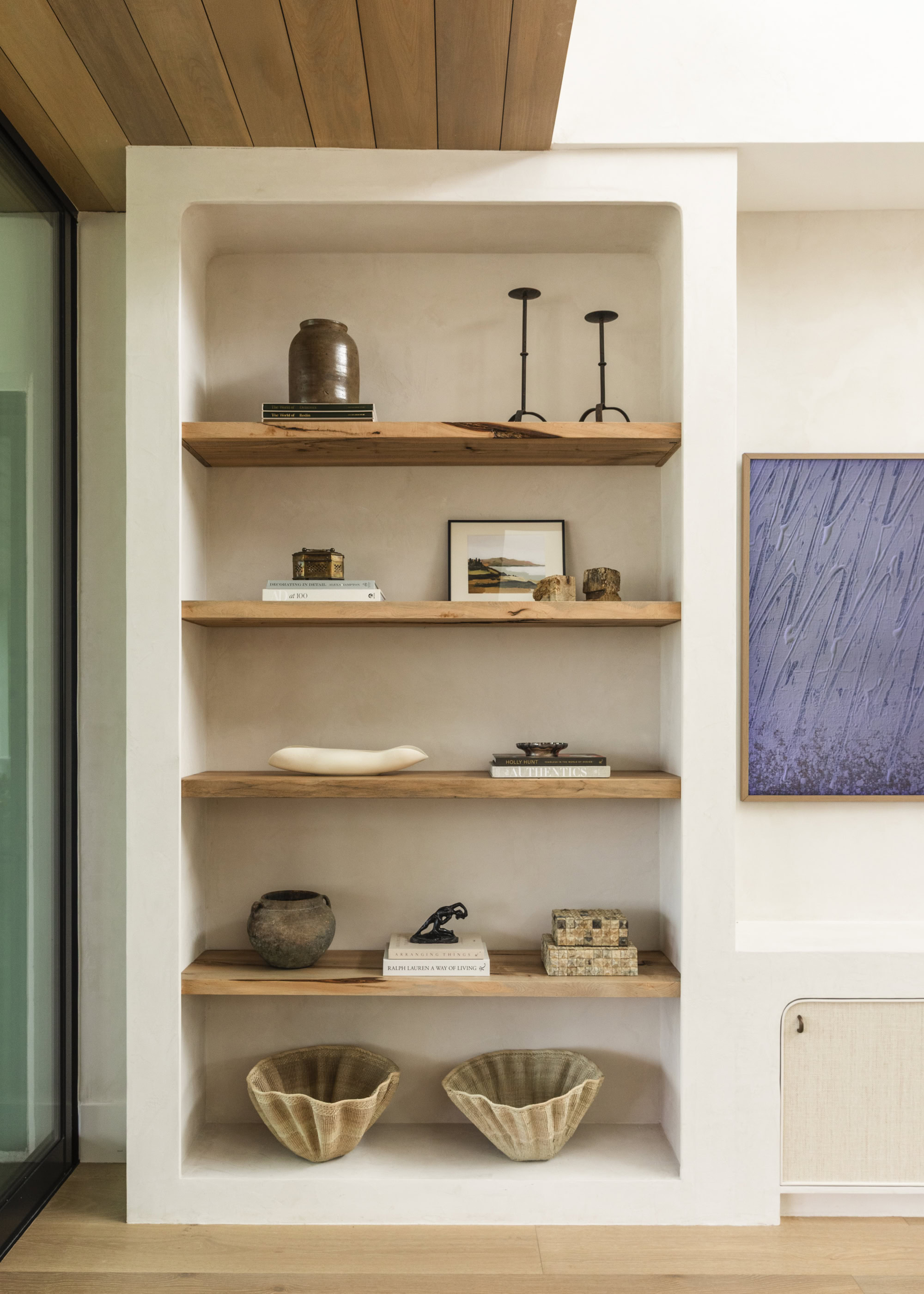 Stylish built-in shelving unit with decorative decor in South Harlow Interiors.
