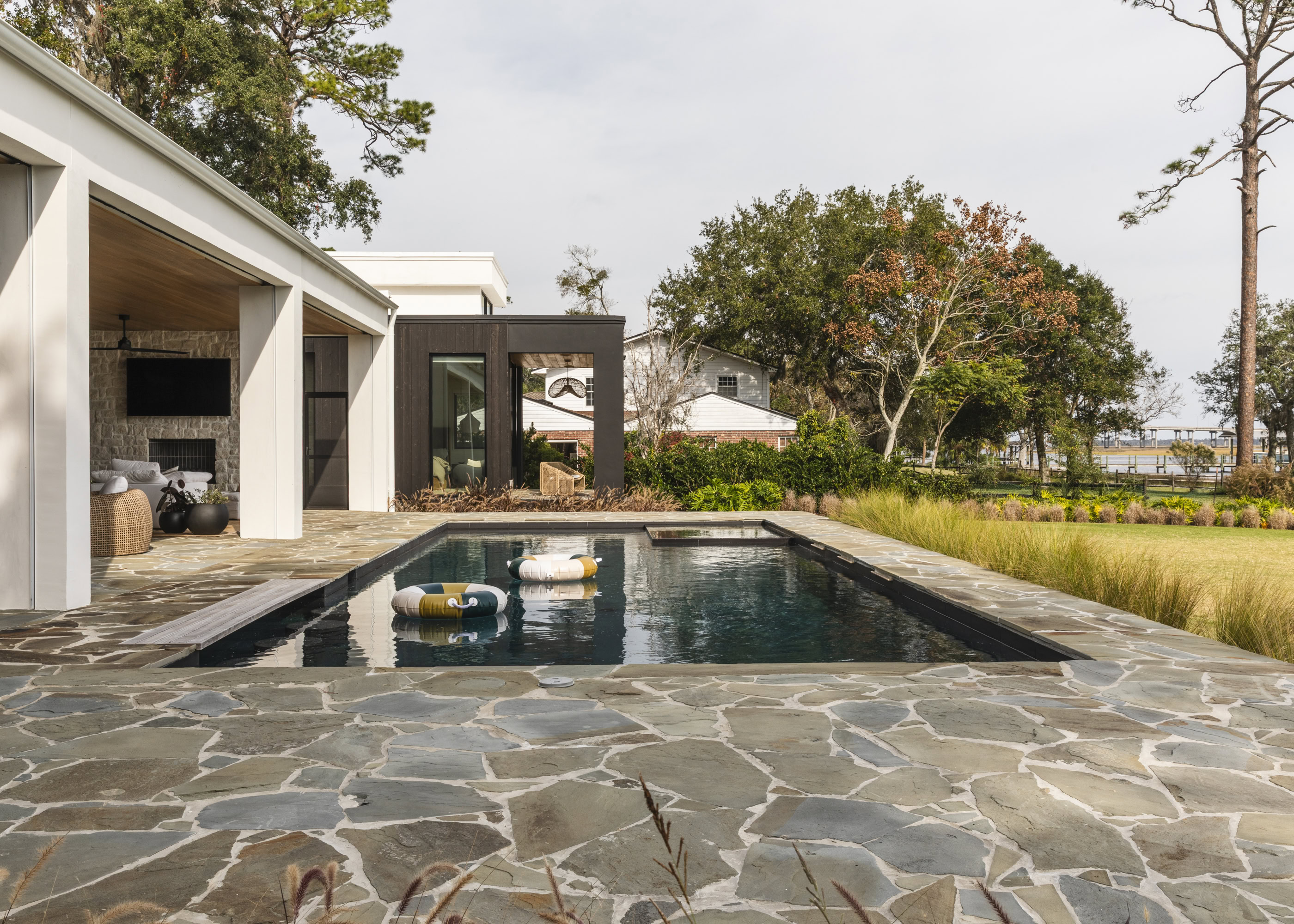 Outdoor pool with stone patio at South Harlow Interiors.