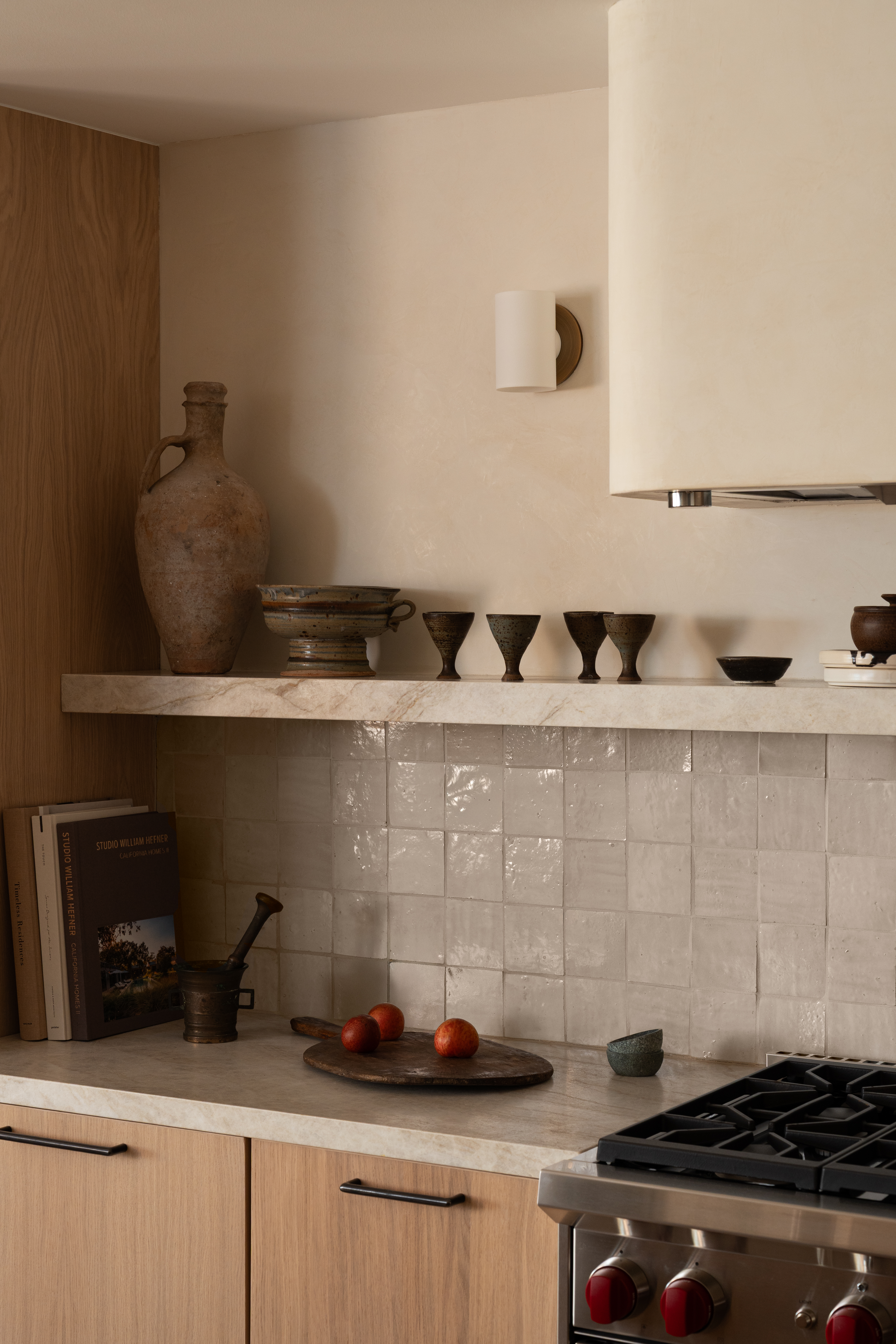 Contemporary kitchen featuring natural wood cabinets, a stone countertop, and decorative pottery for.