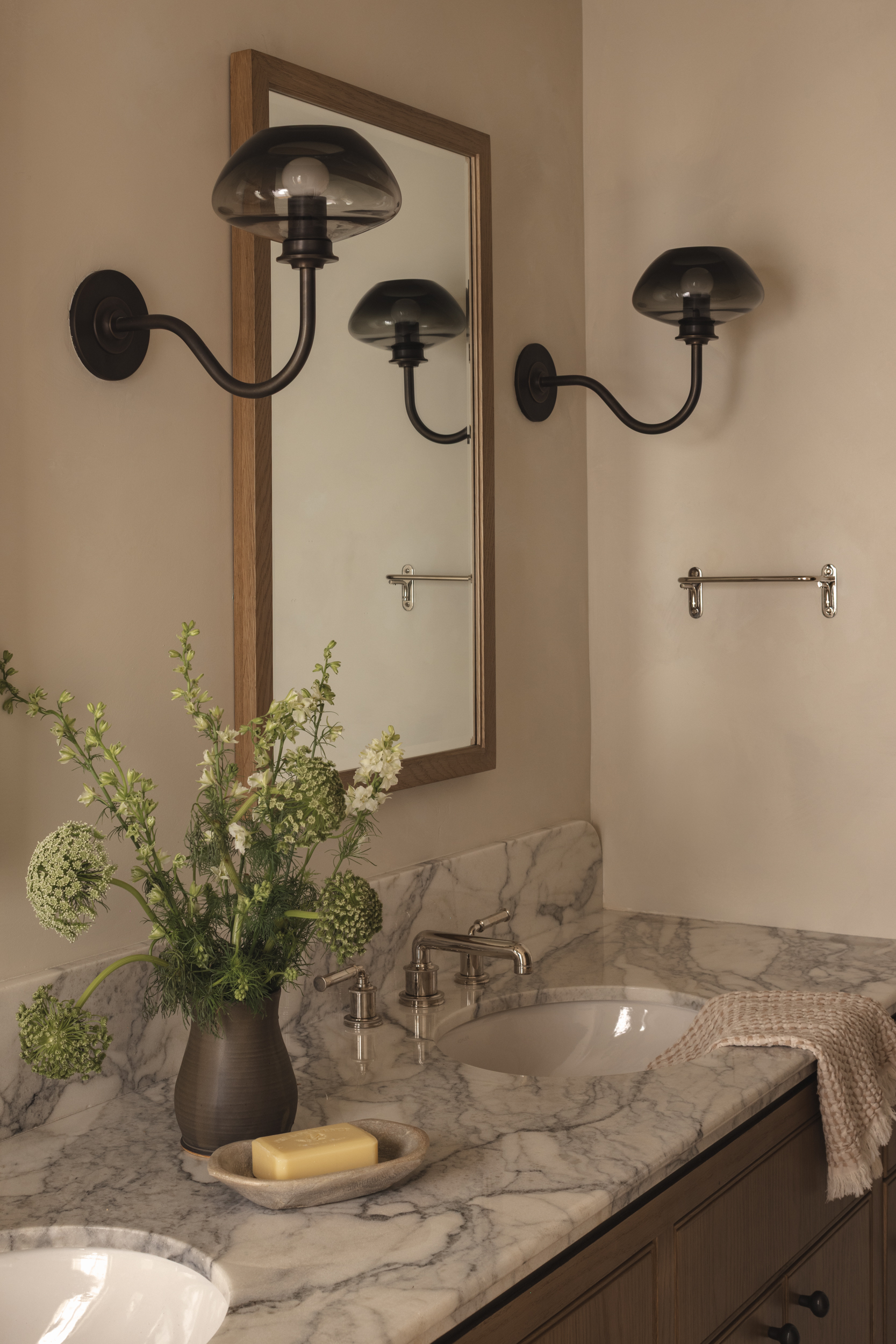 Elegant bathroom with wall-mounted lamps, marble countertop, and mirror.