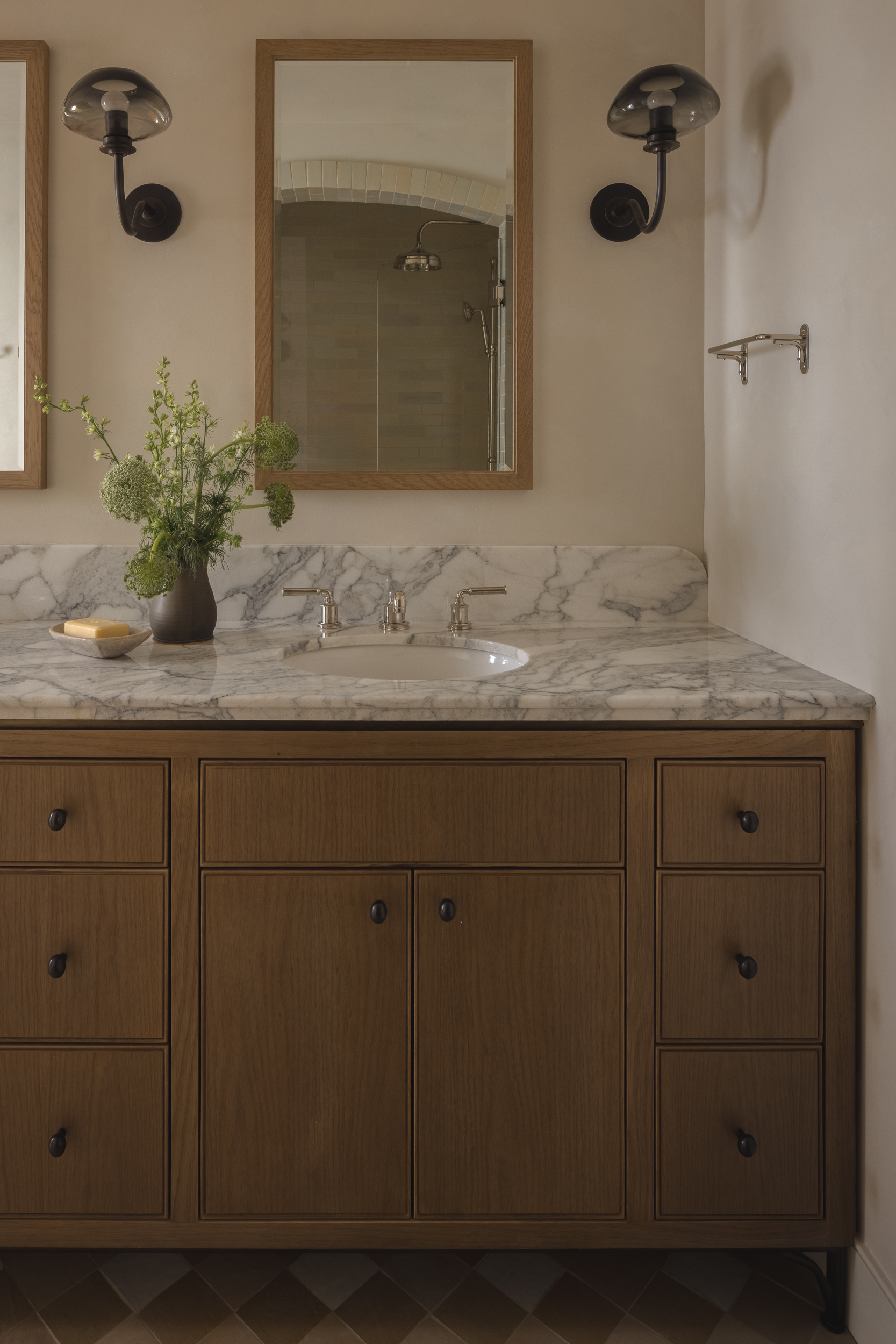 Bathroom vanity with marble countertop and wooden cabinet at South Harlow Interiors.