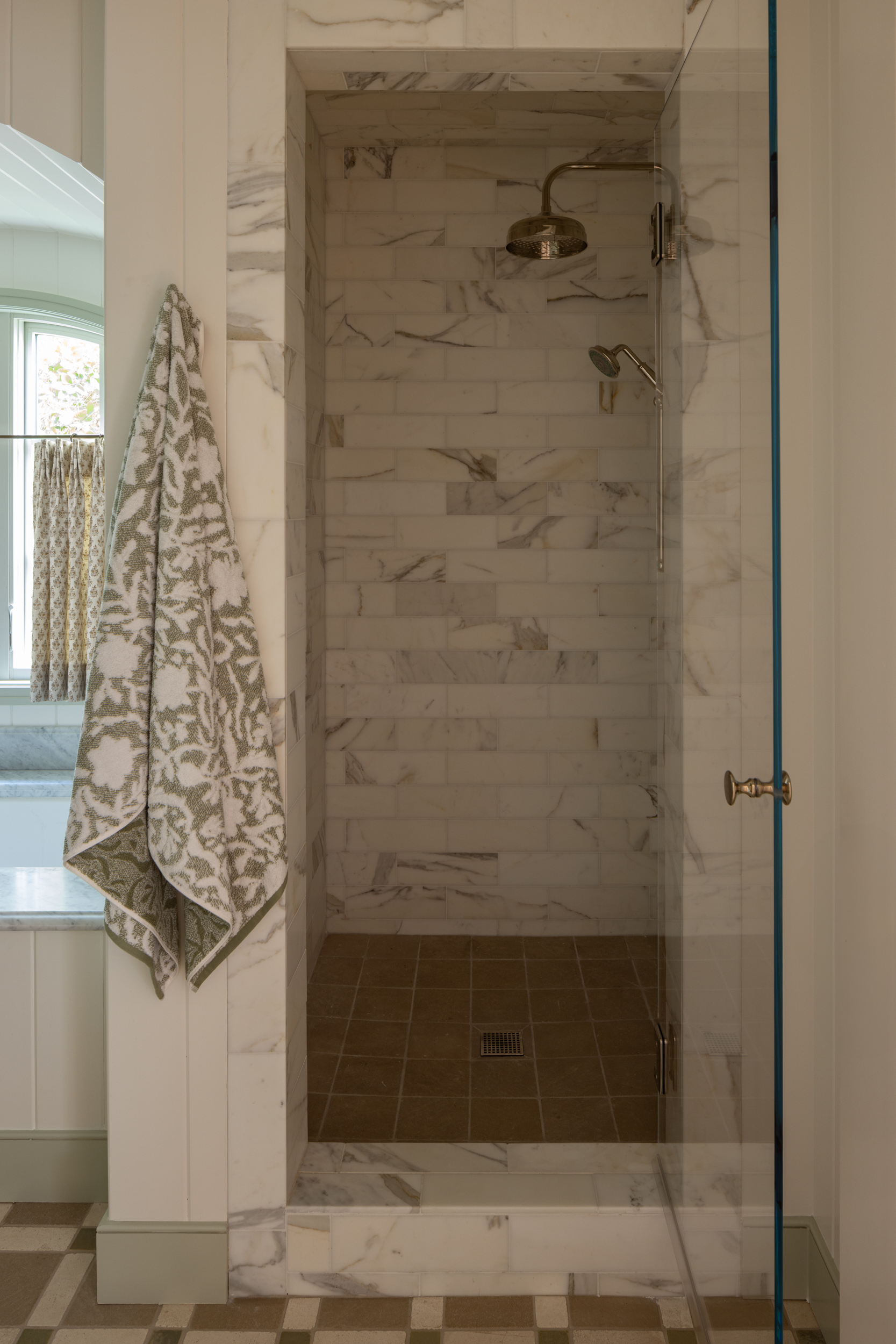 Elegant marble shower with brass fixtures in a contemporary bathroom.