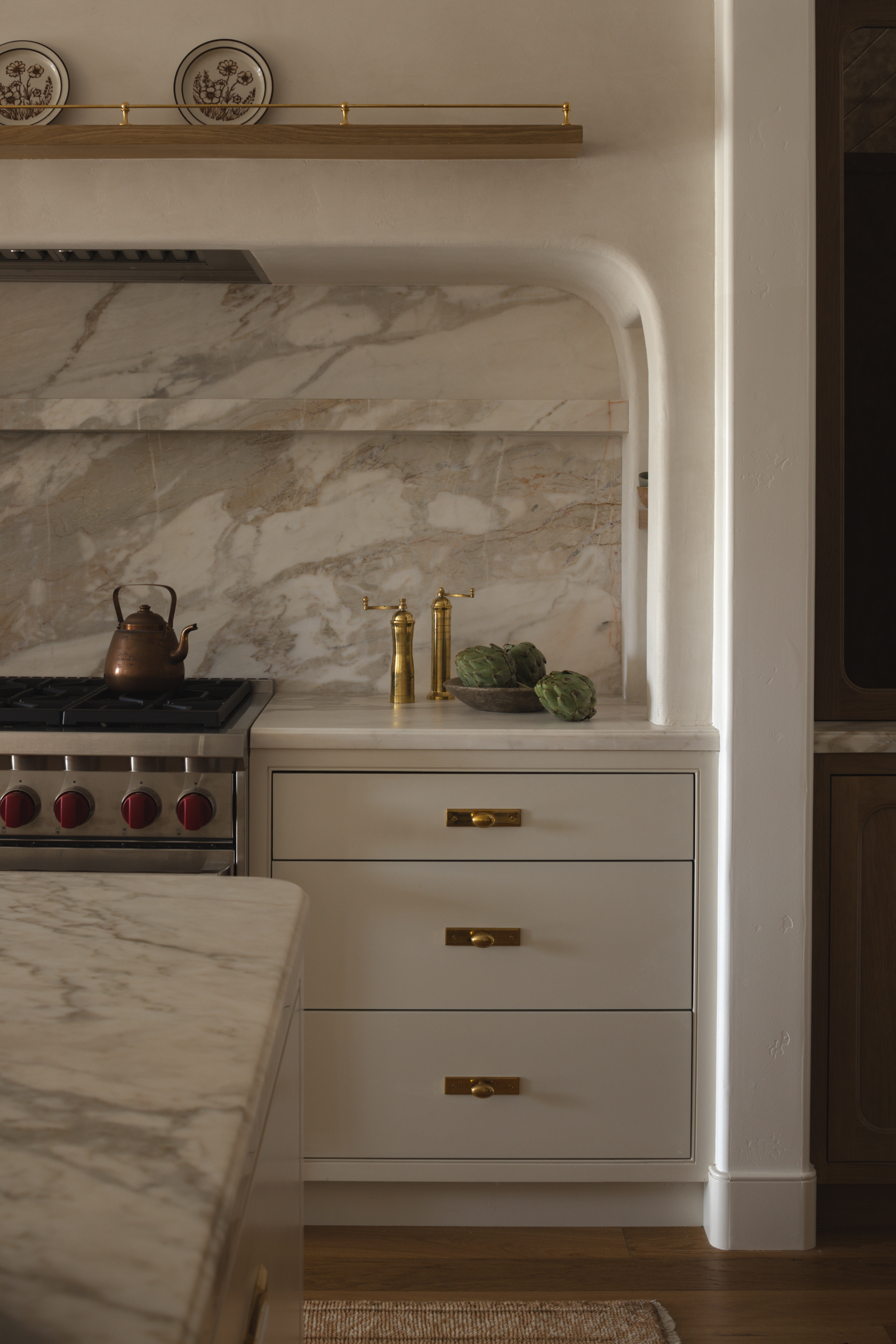 Elegant kitchen with marble countertops and gold fixtures at South Harlow Interiors.