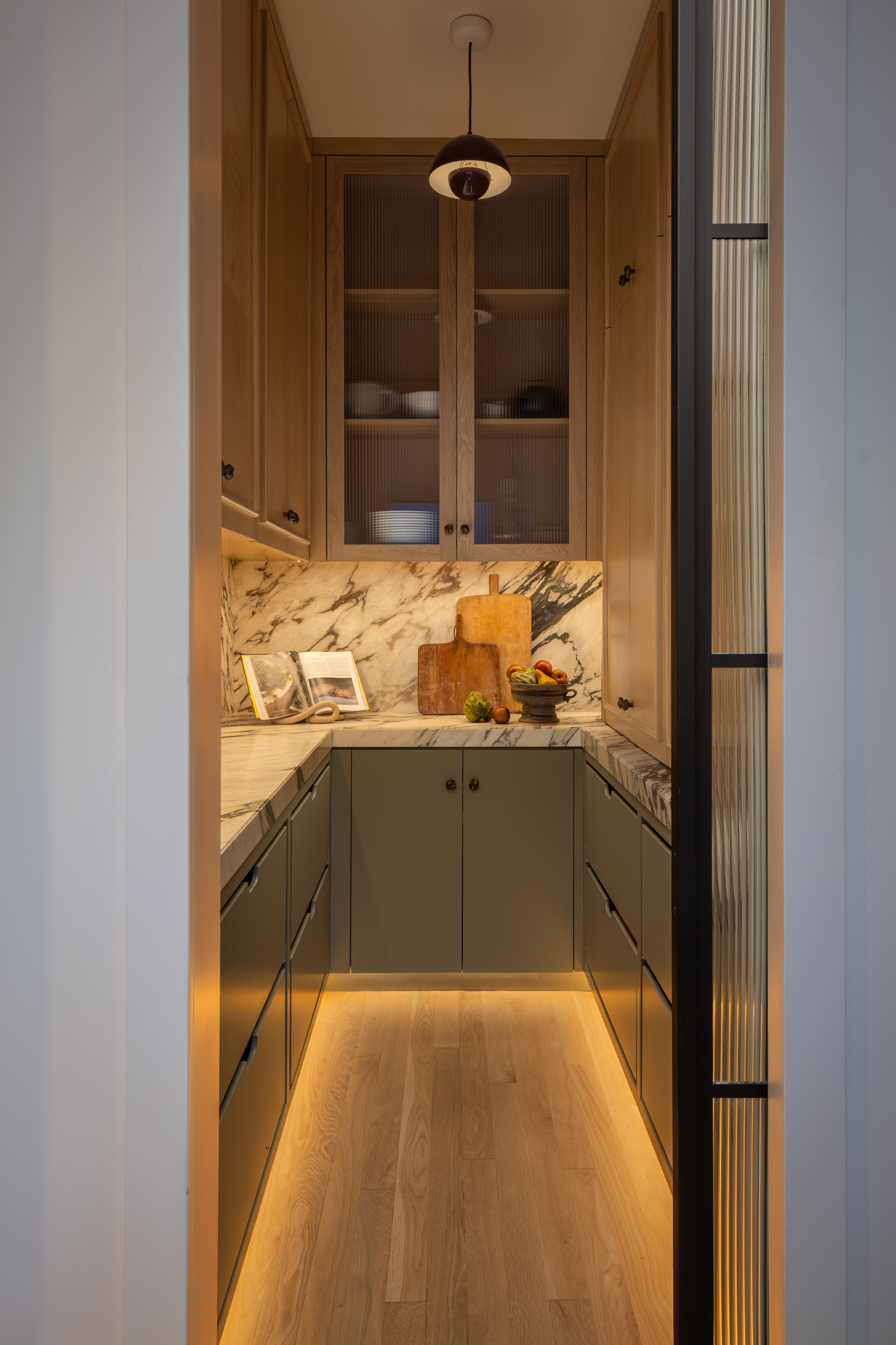 Modern kitchen with wooden cabinets and marble backsplash at South Harlow Interiors.