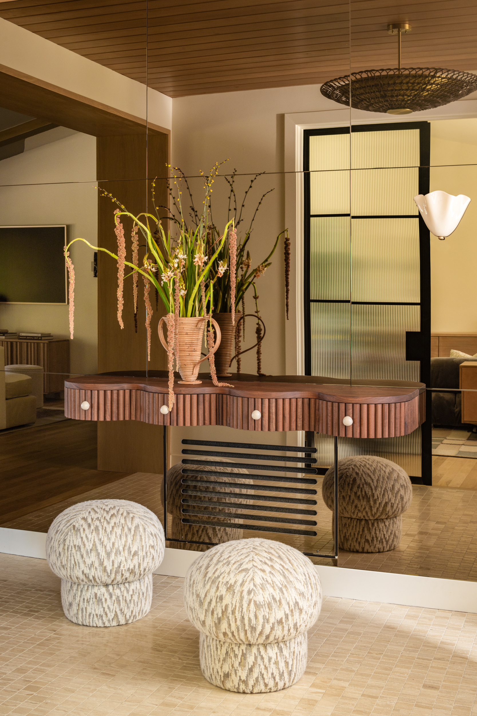 Elegant interior with a wooden console table and textured ottomans.