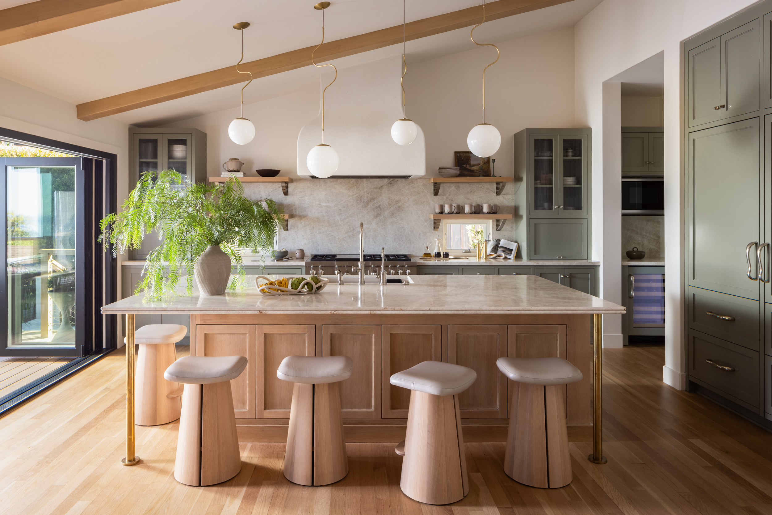 Contemporary kitchen with island, pendant lights, and green cabinetry.