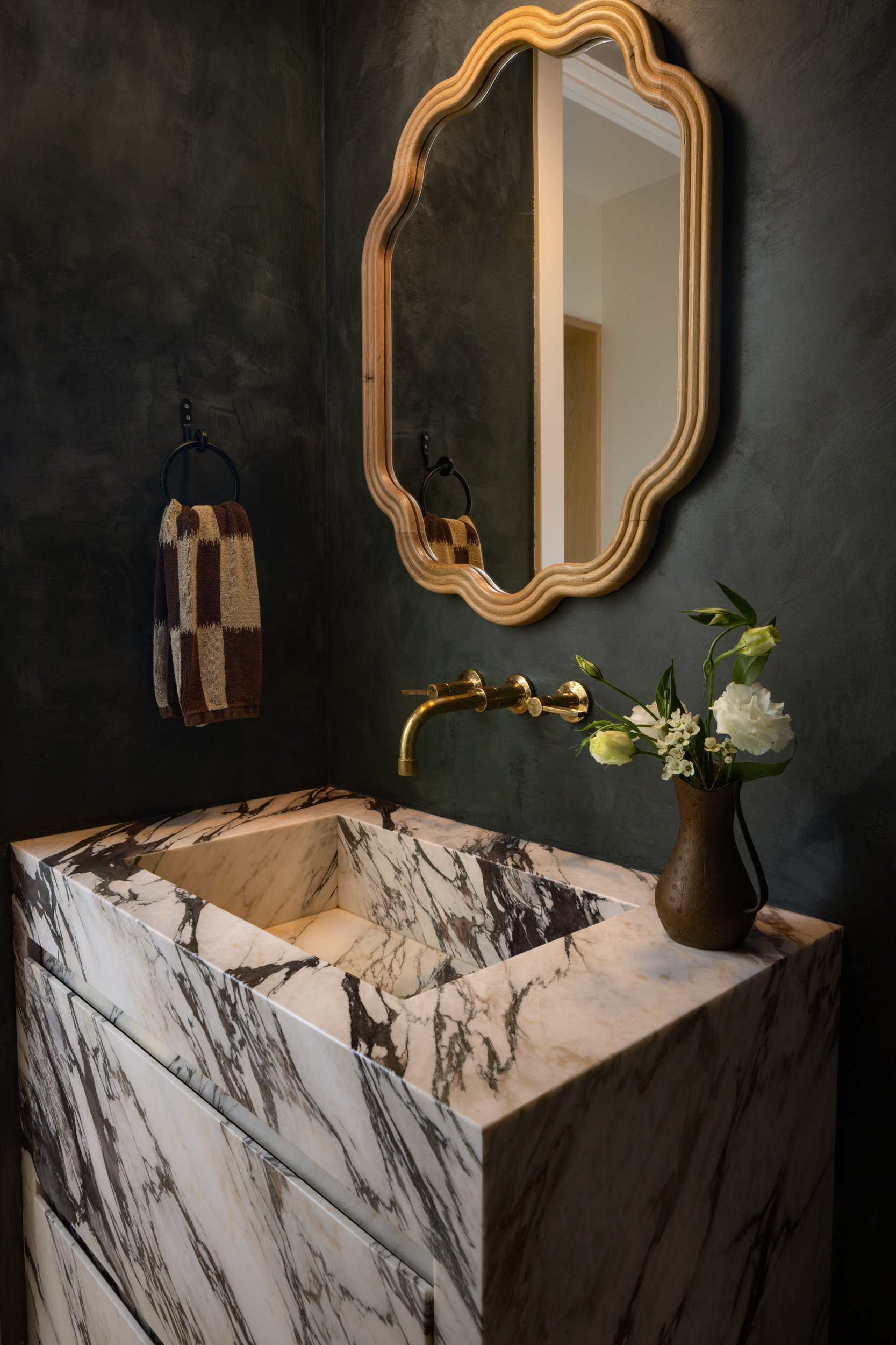 Elegant bathroom with marble sink, gold fixtures, and decorative mirror.