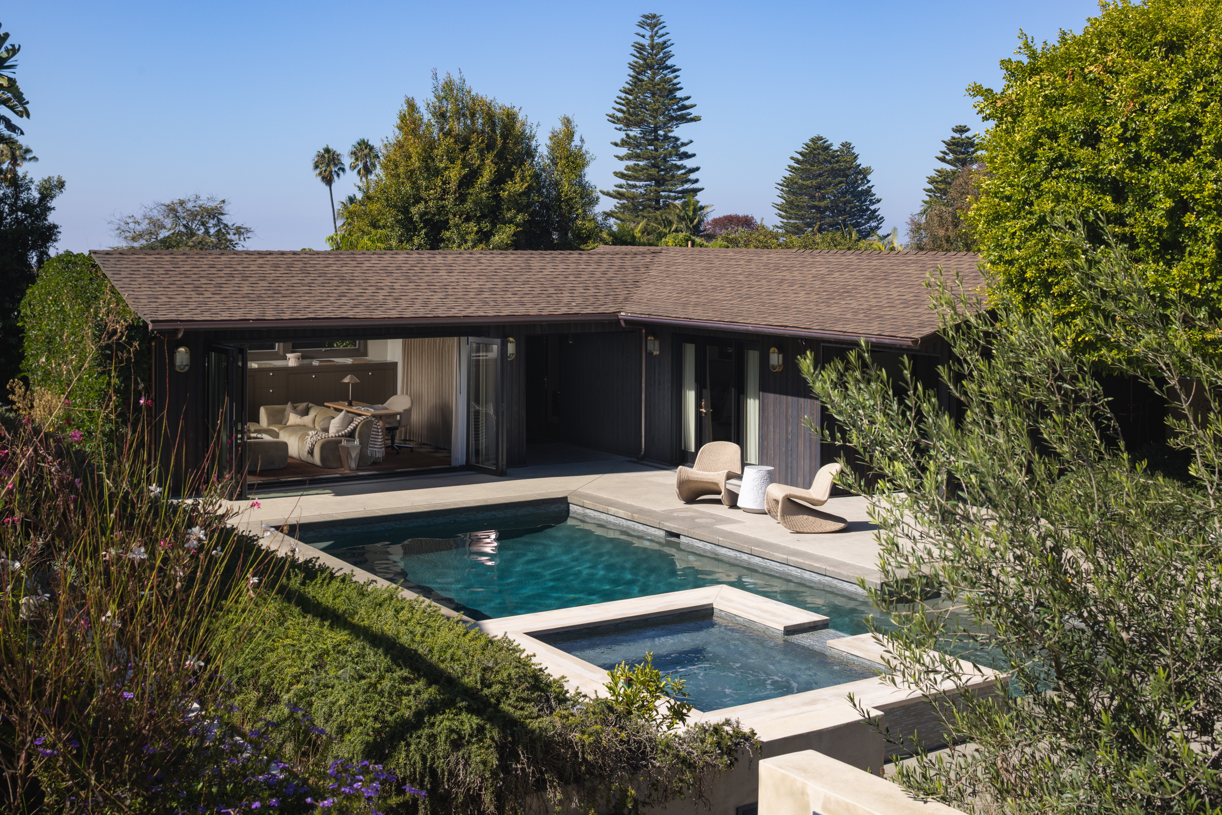 Contemporary house with pool, outdoor seating, and lush garden.