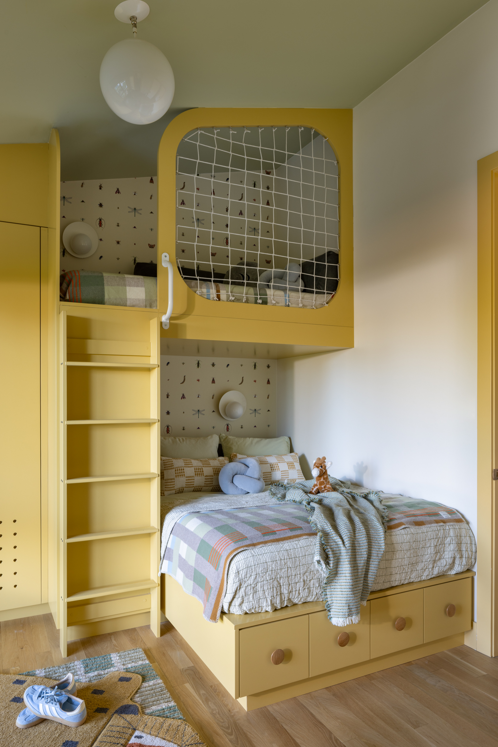 Colorful children's bedroom with yellow furniture and playful design elements.