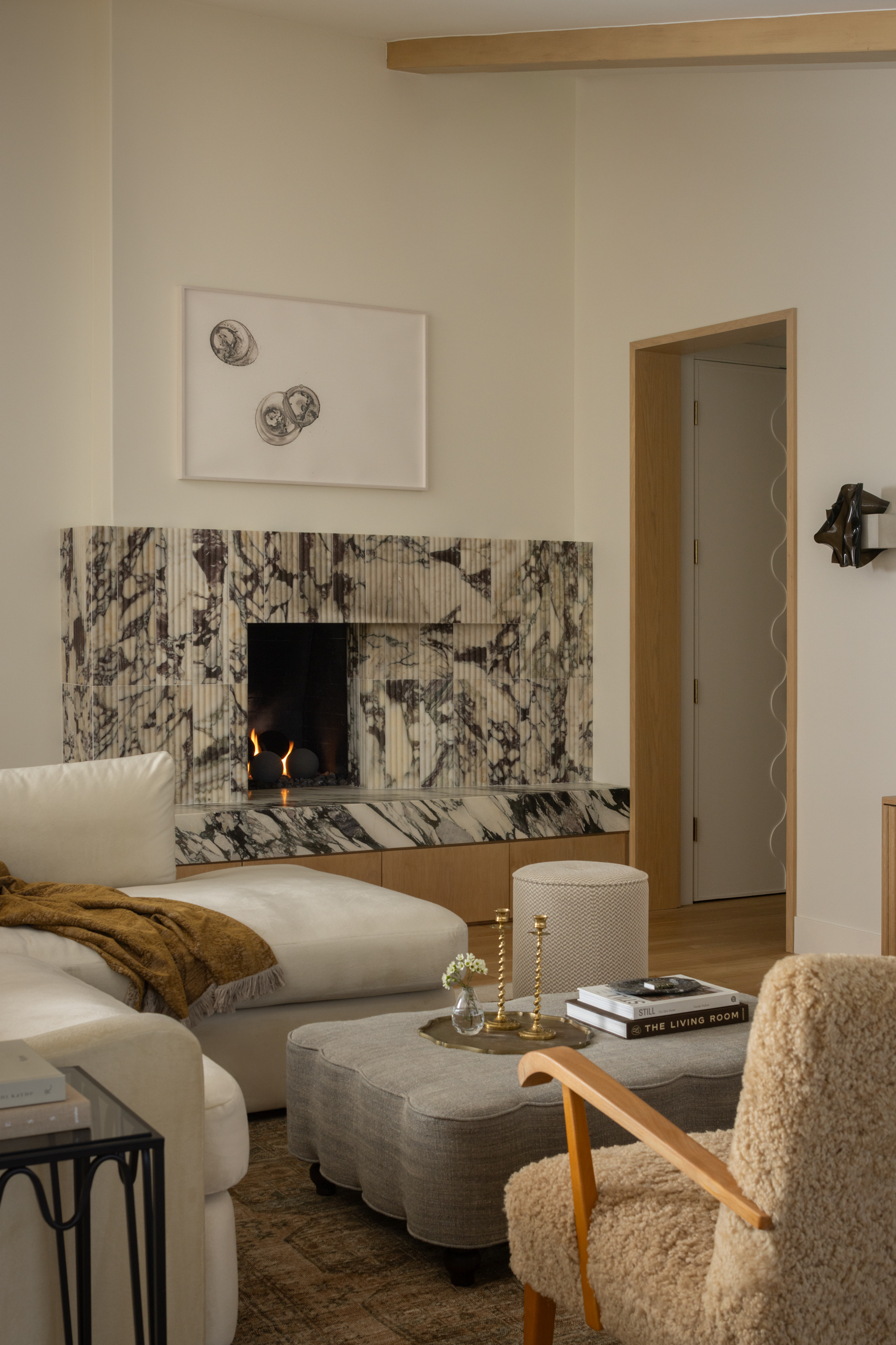 Modern living room with fireplace, neutral tones, and stylish decor.