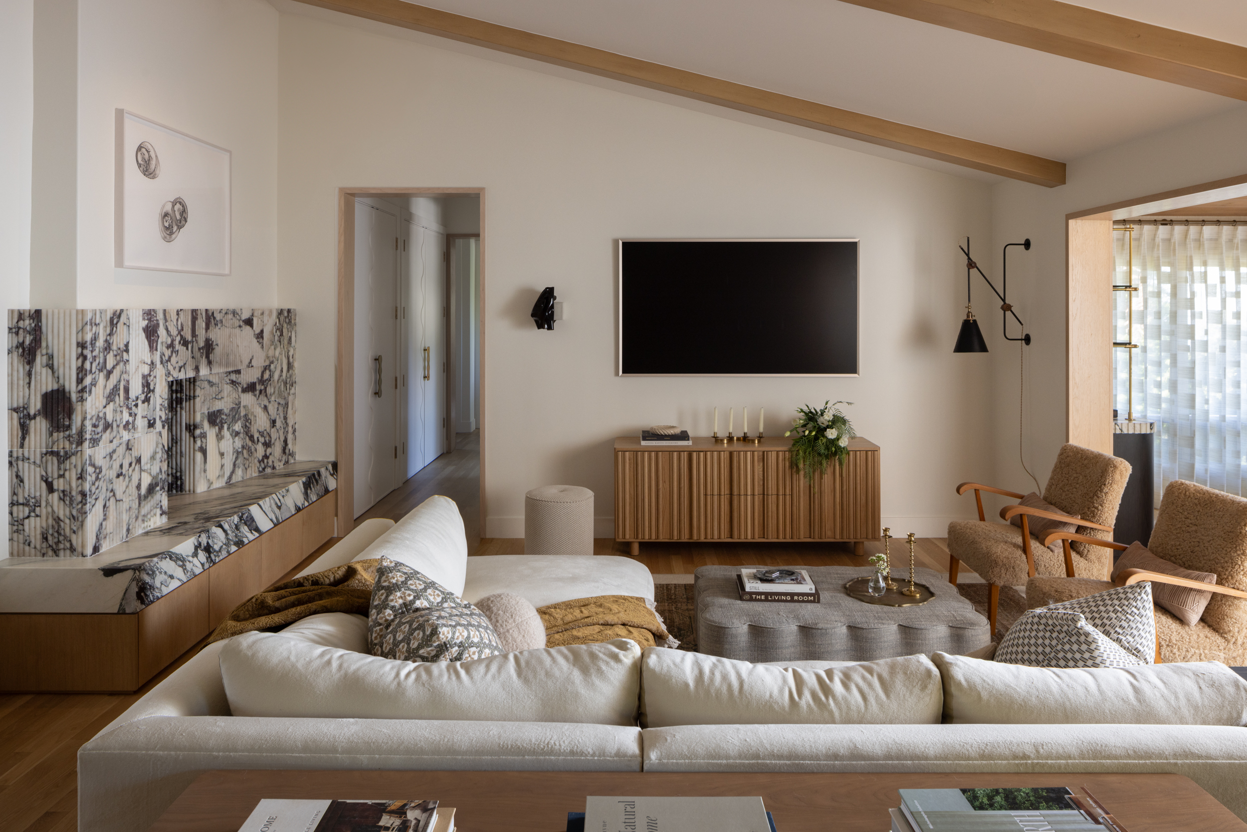 Modern living room with neutral tones, wooden accents, and contemporary furniture.