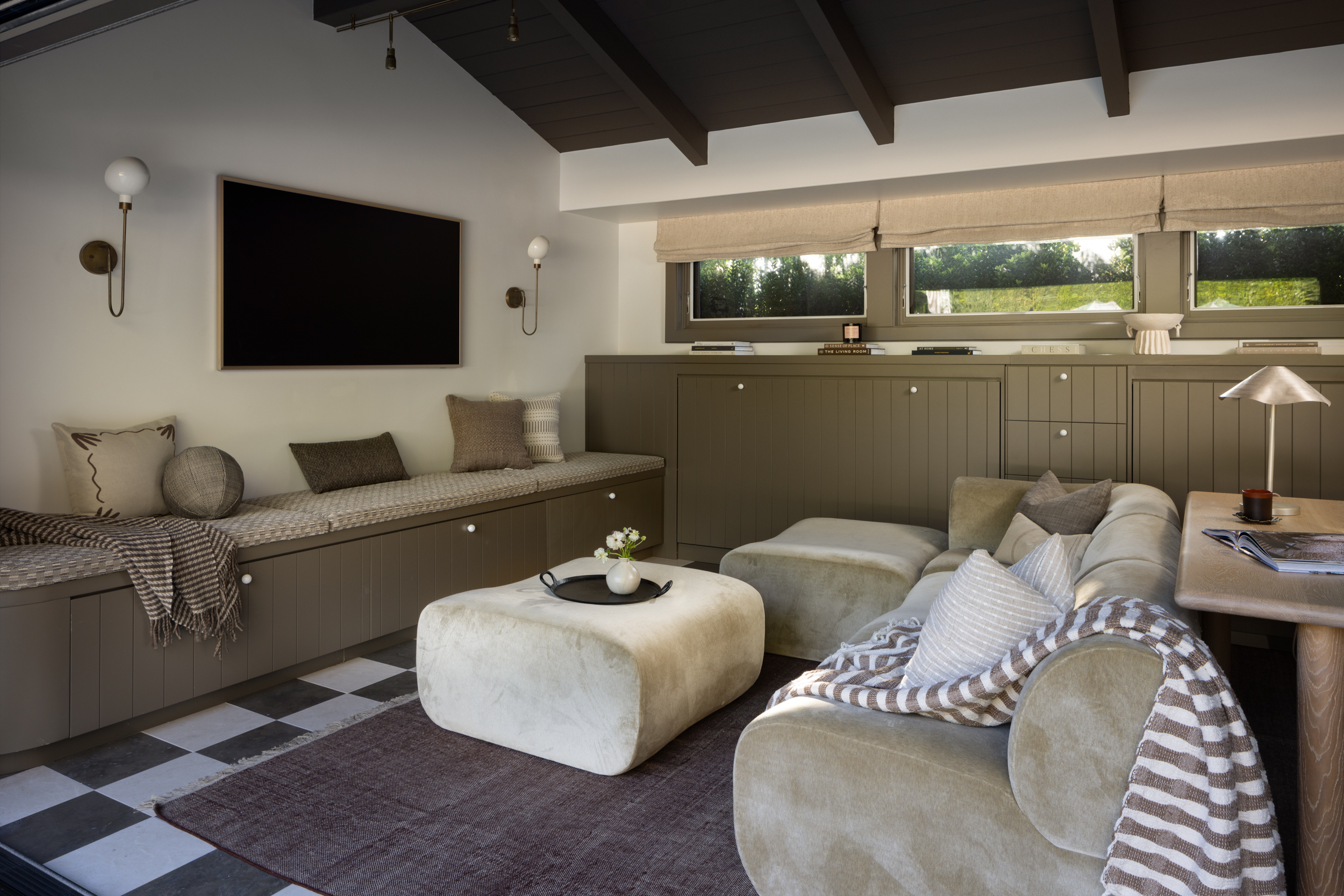 Modern living room with neutral tones, cozy seating, and large windows.