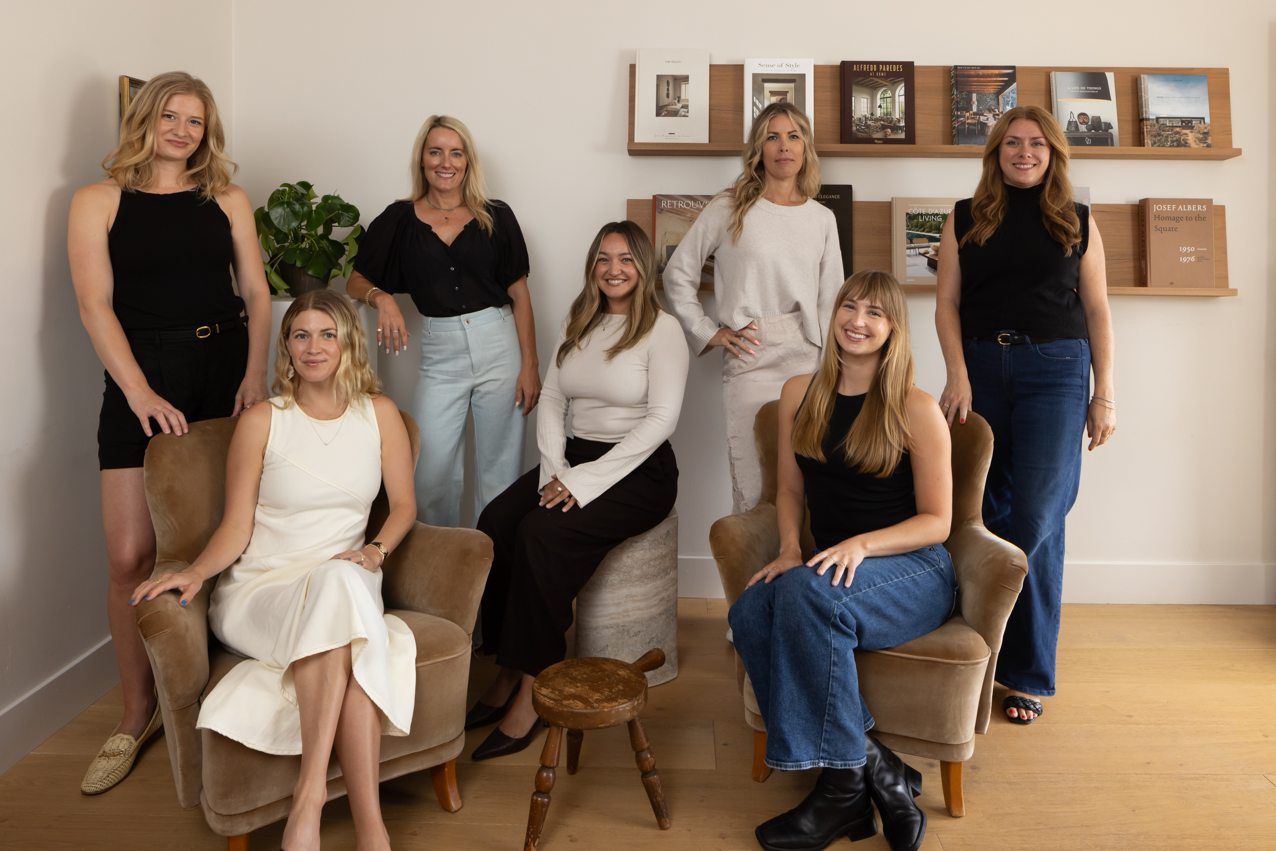 Group of seven women in a modern interior space at South Harlow Interiors.