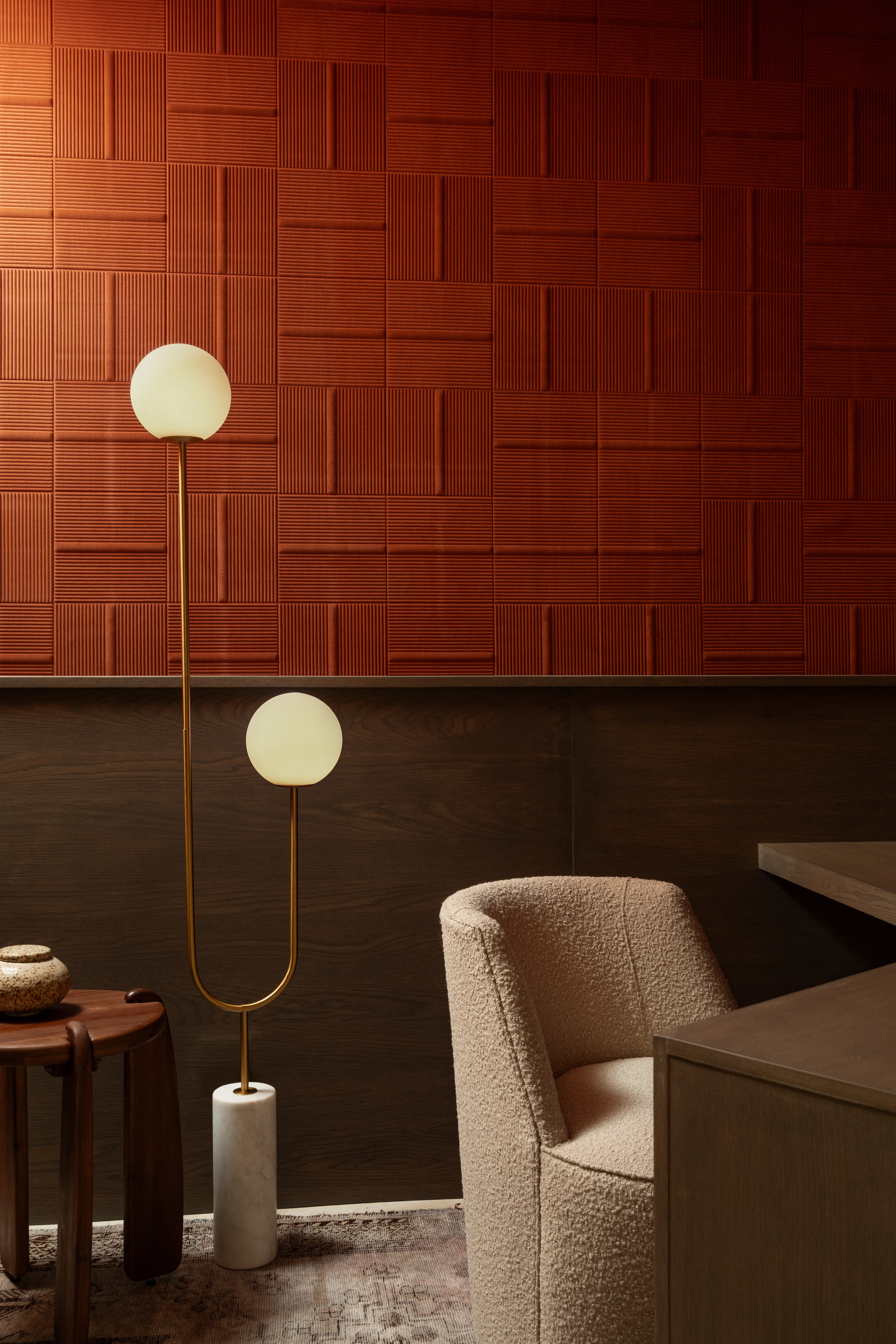 Layered red tile wall and lounge chair in the IOwn office.
