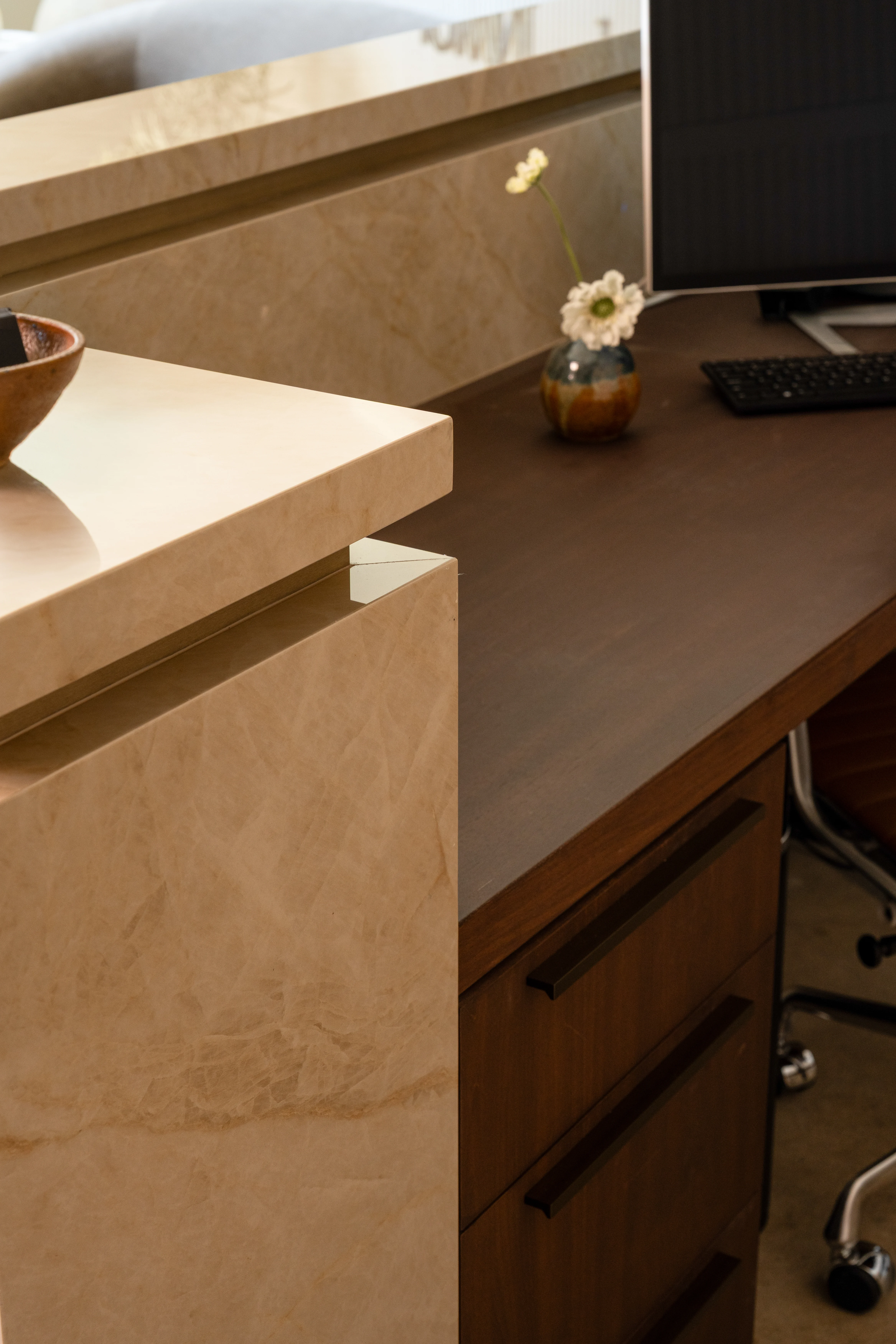 Layered stone and wood detail at the IOwn reception desk.