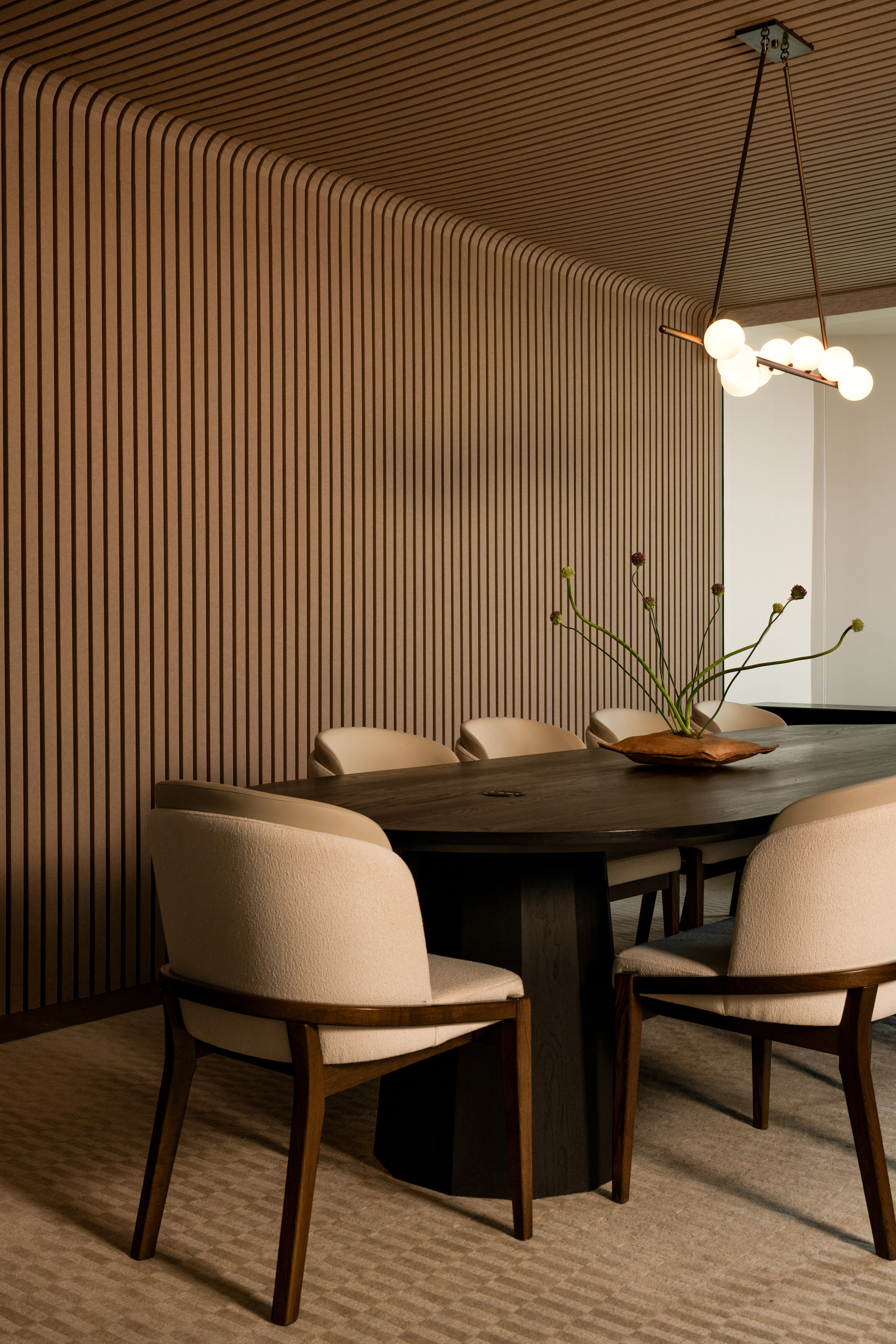 IOwn conference room with fluted wood walls and sculptural lighting.