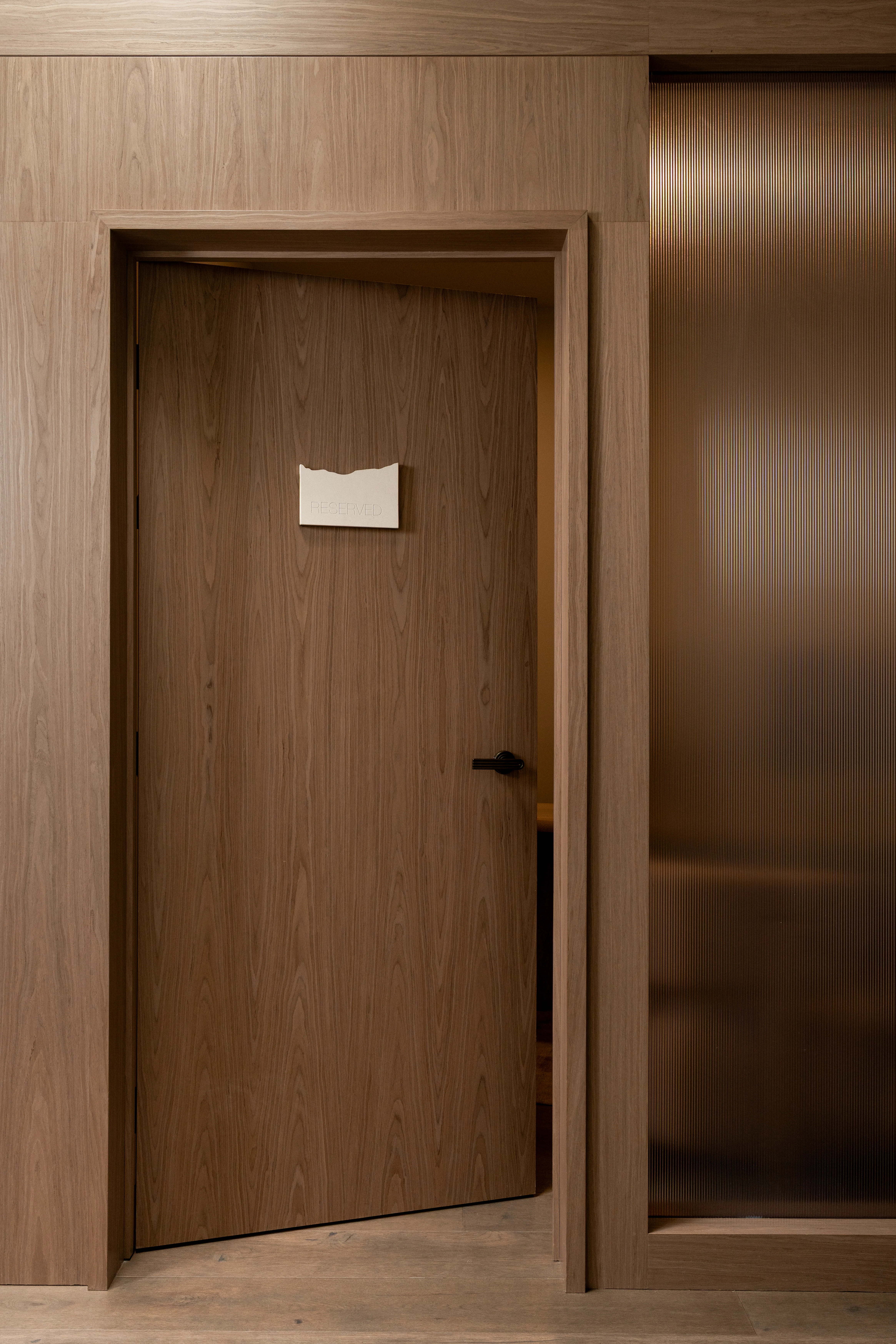 Wood door to a private telephone room.