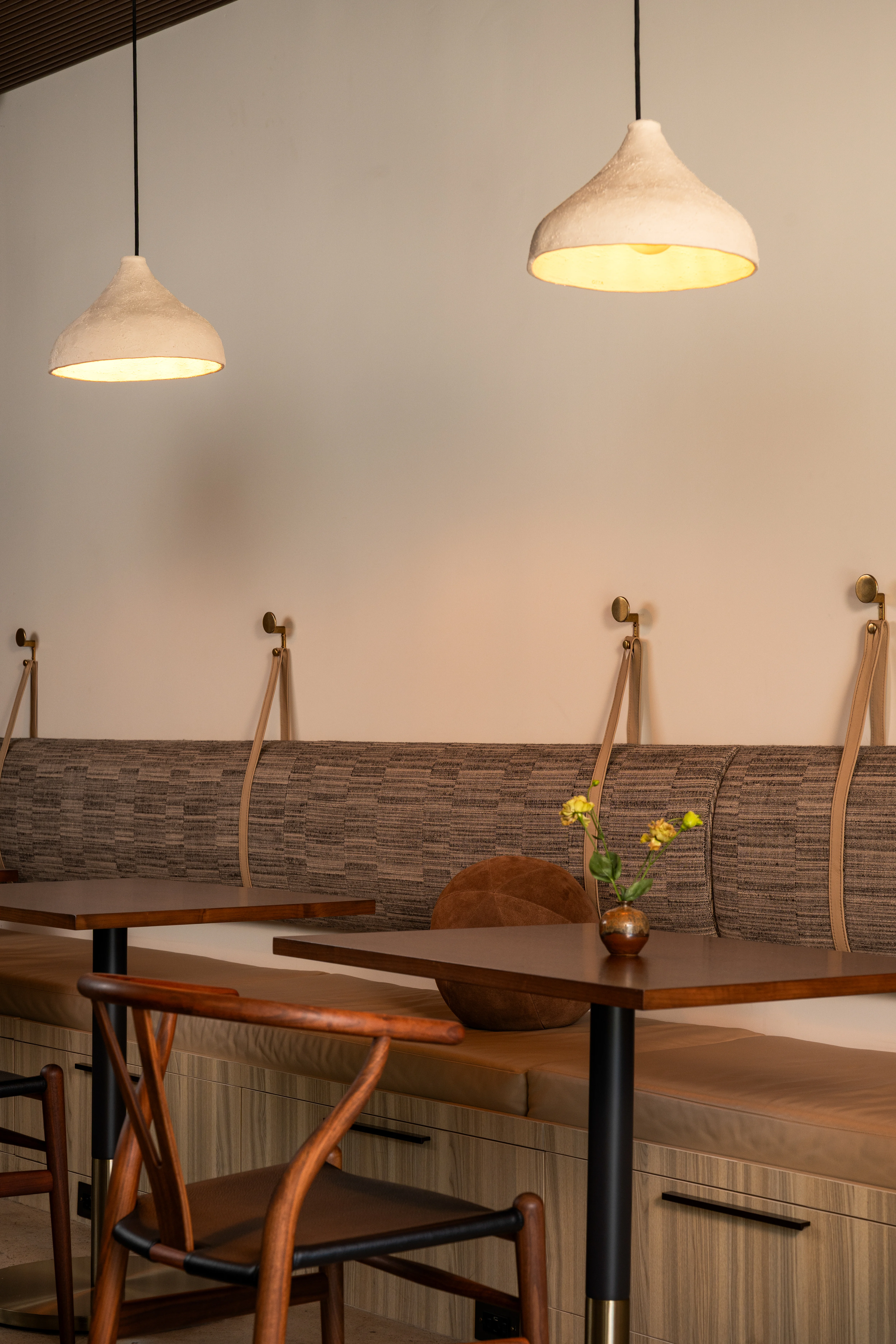 Banquette meeting area with warm wood and pendant lighting.