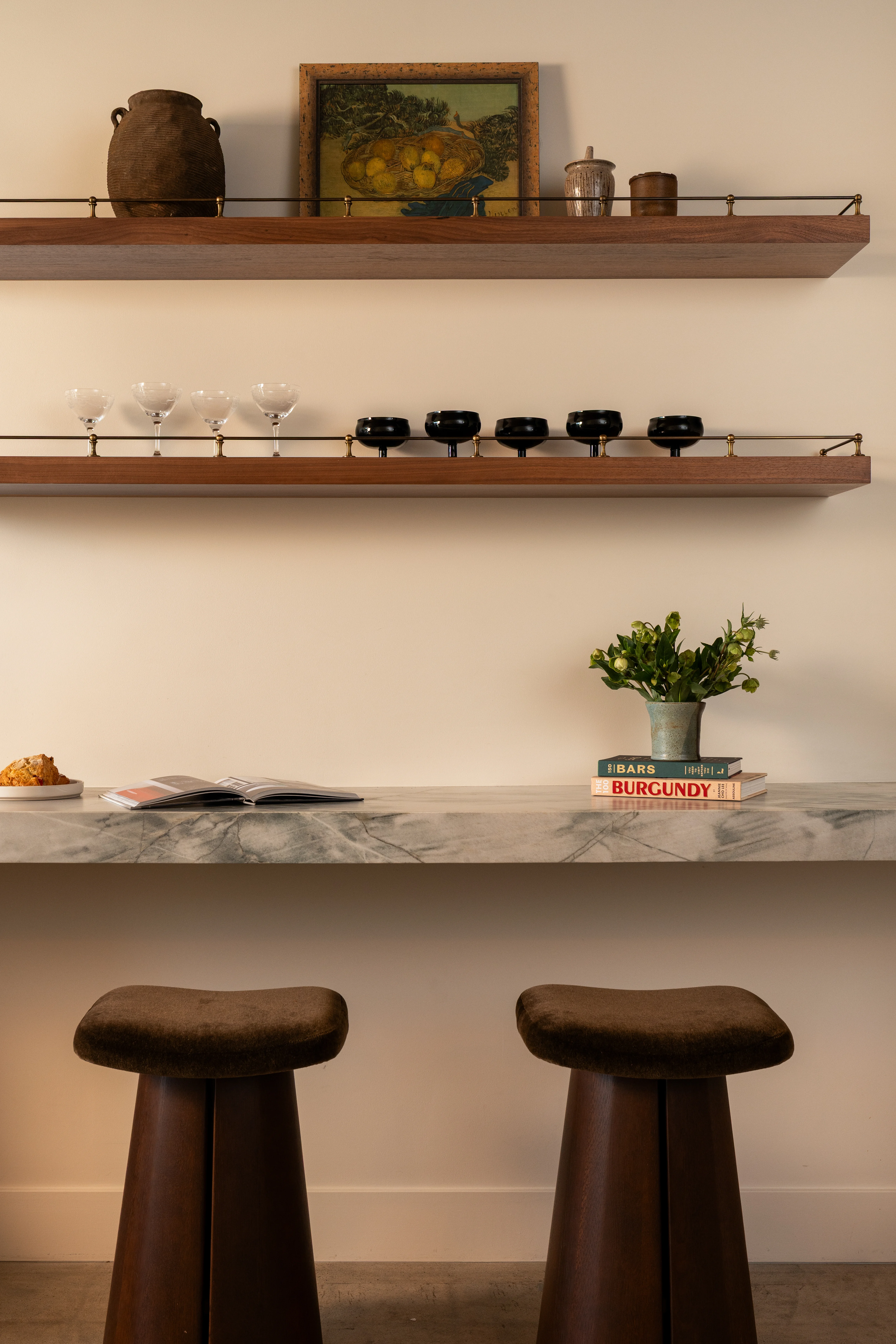 Office kitchen with open wood shelves and sculptural stools.