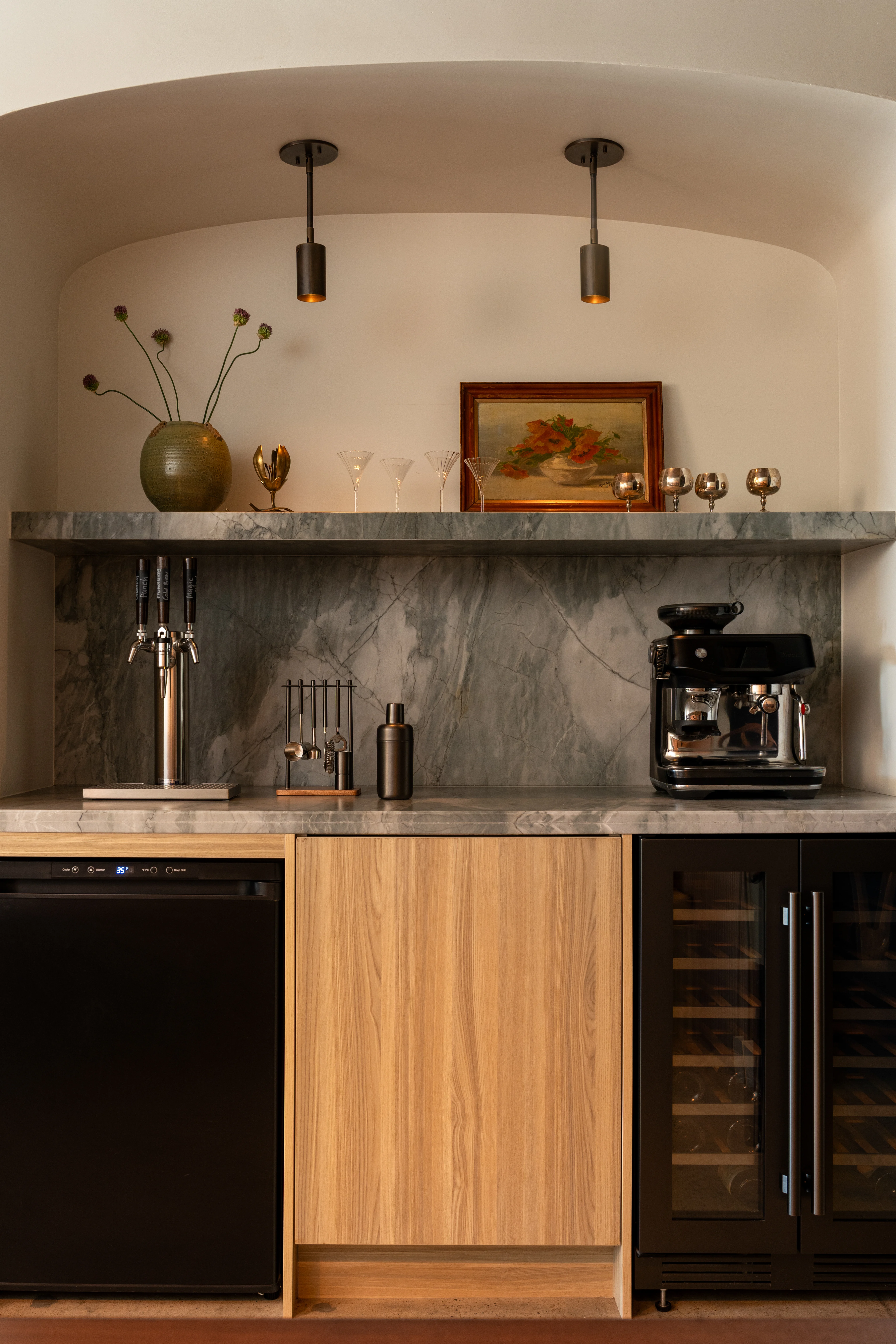 Compact coffee bar with marble backsplash and warm wood cabinetry.