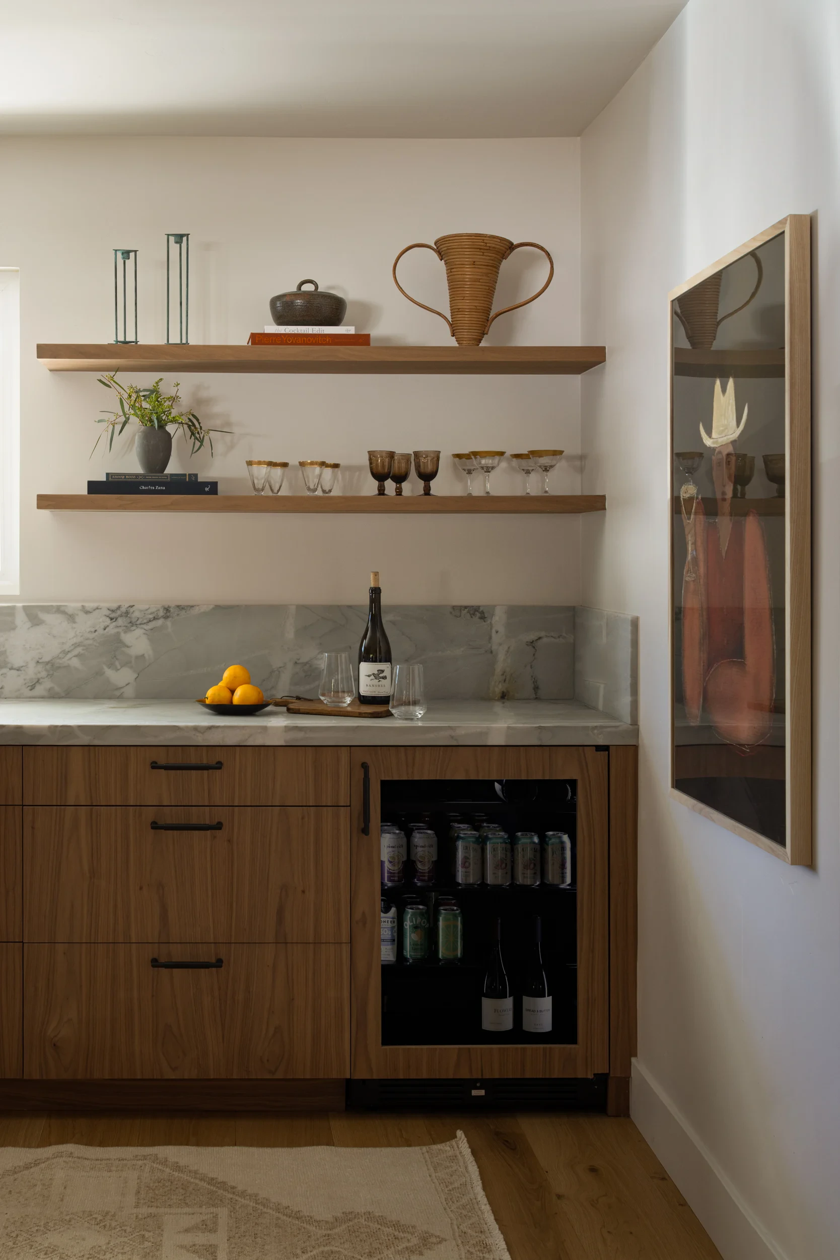 Bar nook with floating walnut shelves, quartzite backsplash, and a built-in wine fridge.